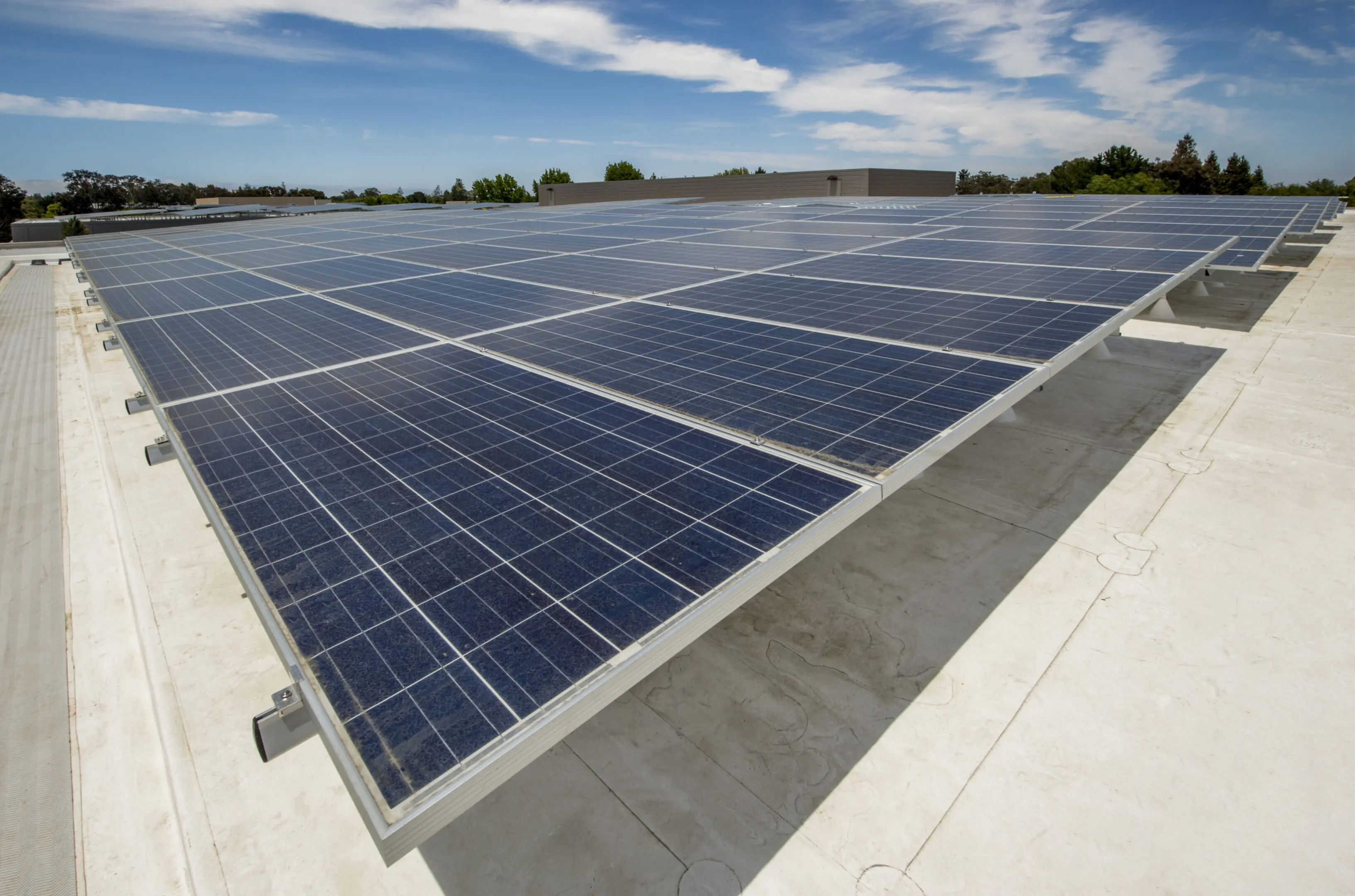 Large array of solar panels on the roof of an new office building.