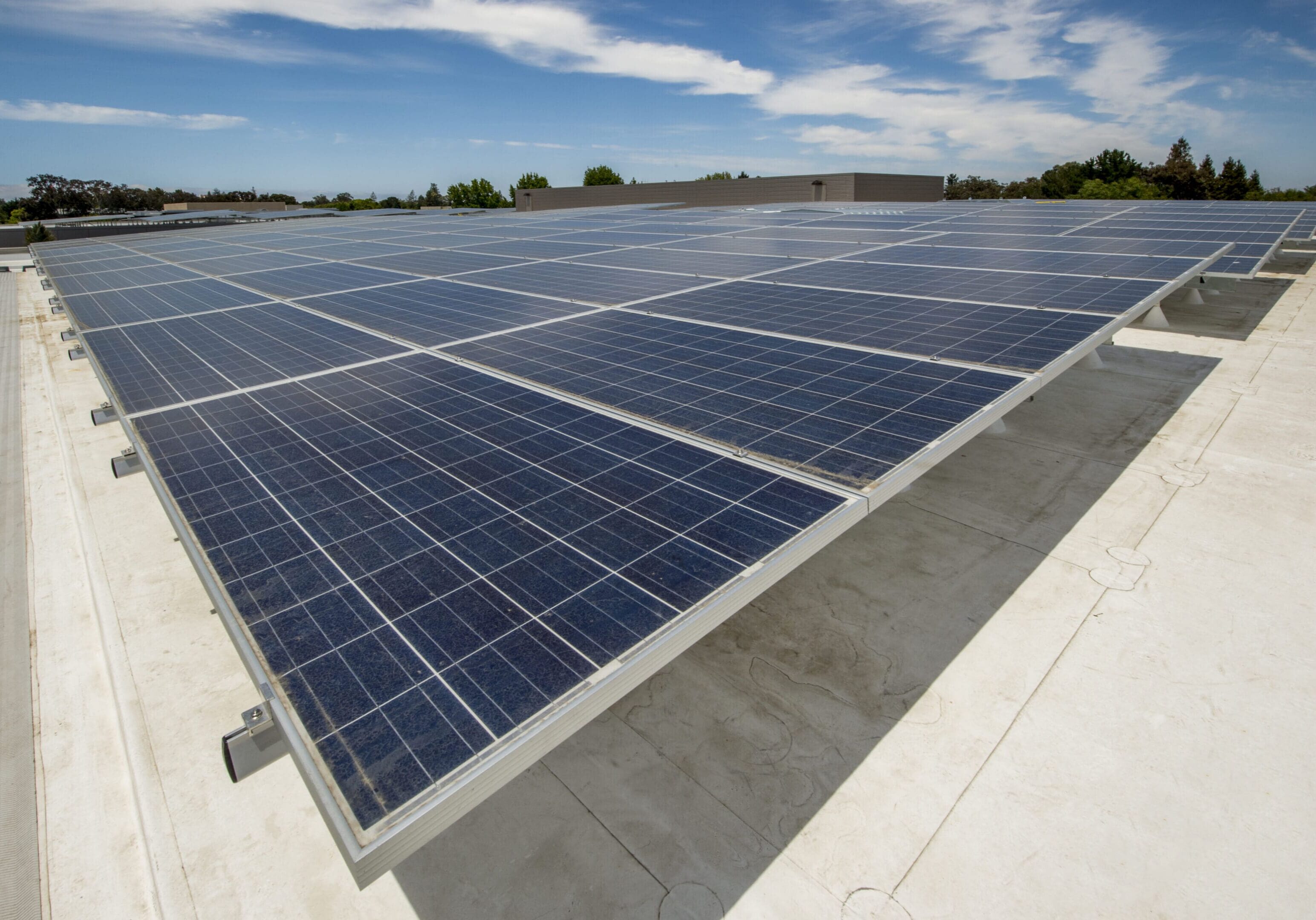 Large array of solar panels on the roof of an new office building.